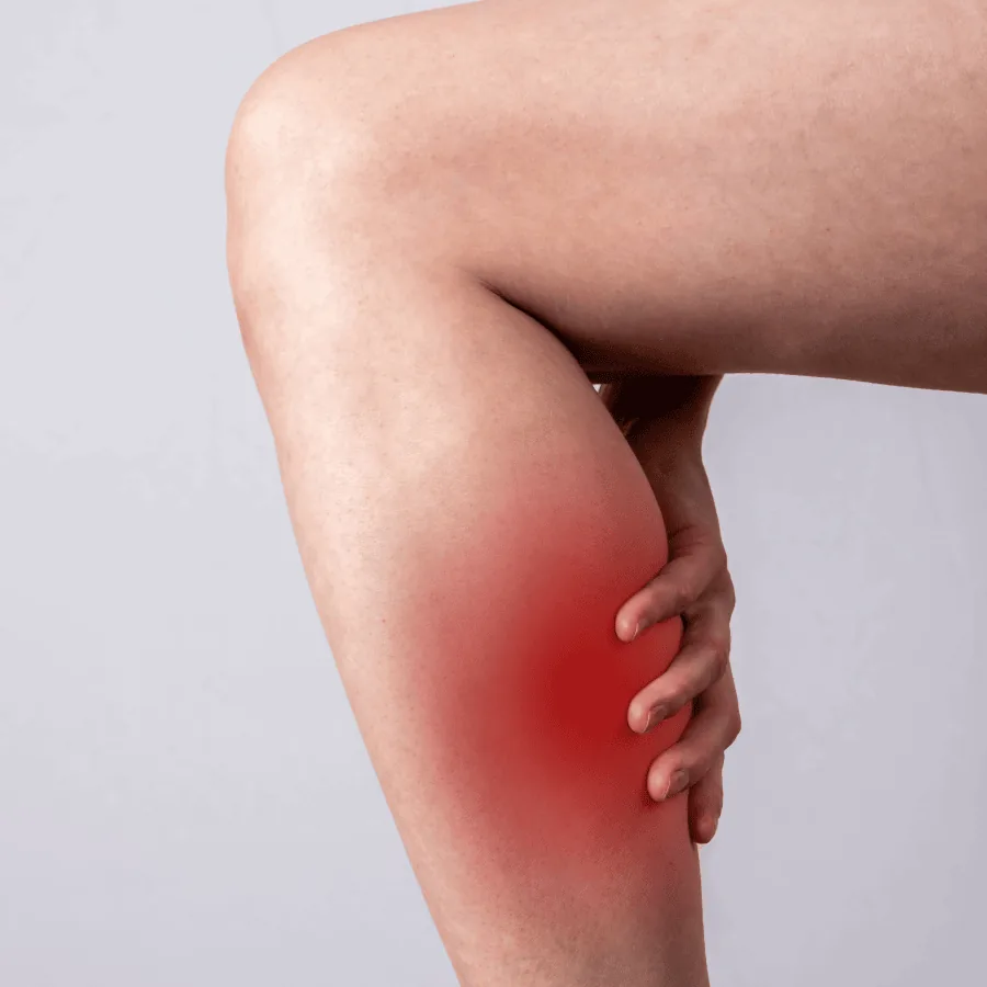 Person holding the back of their calf, the painful area highlighted in red